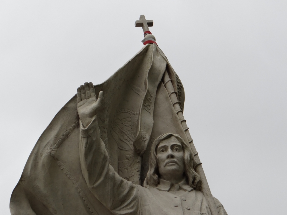 十字架前挥手的男人雕像