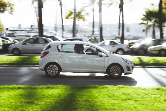 早晨城市马路疾驰的白色轿车