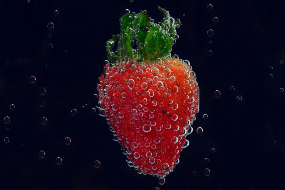 清澈水中浸泡红色草莓气泡特写