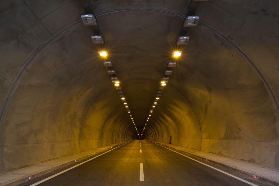 暗黄灯光照亮着的公路隧道