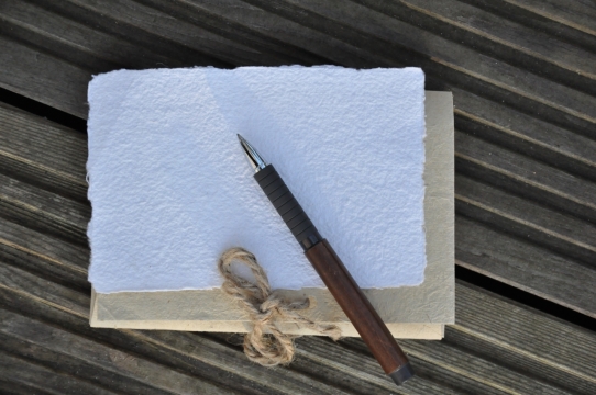 条纹木板上摆放着记事本和水笔静物摄影