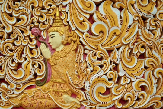 黄色云纹侧坐佛像浮雕特写