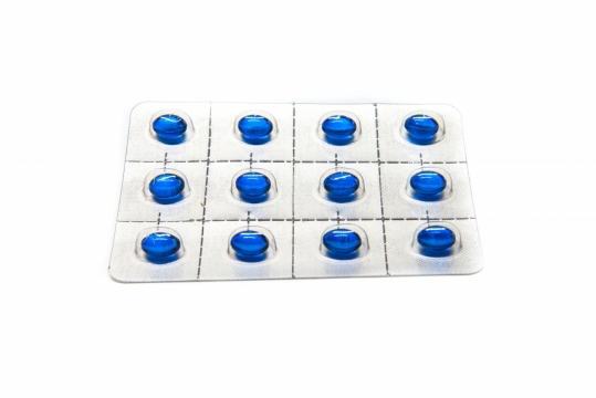 简约白色背景板装蓝色胶囊药物