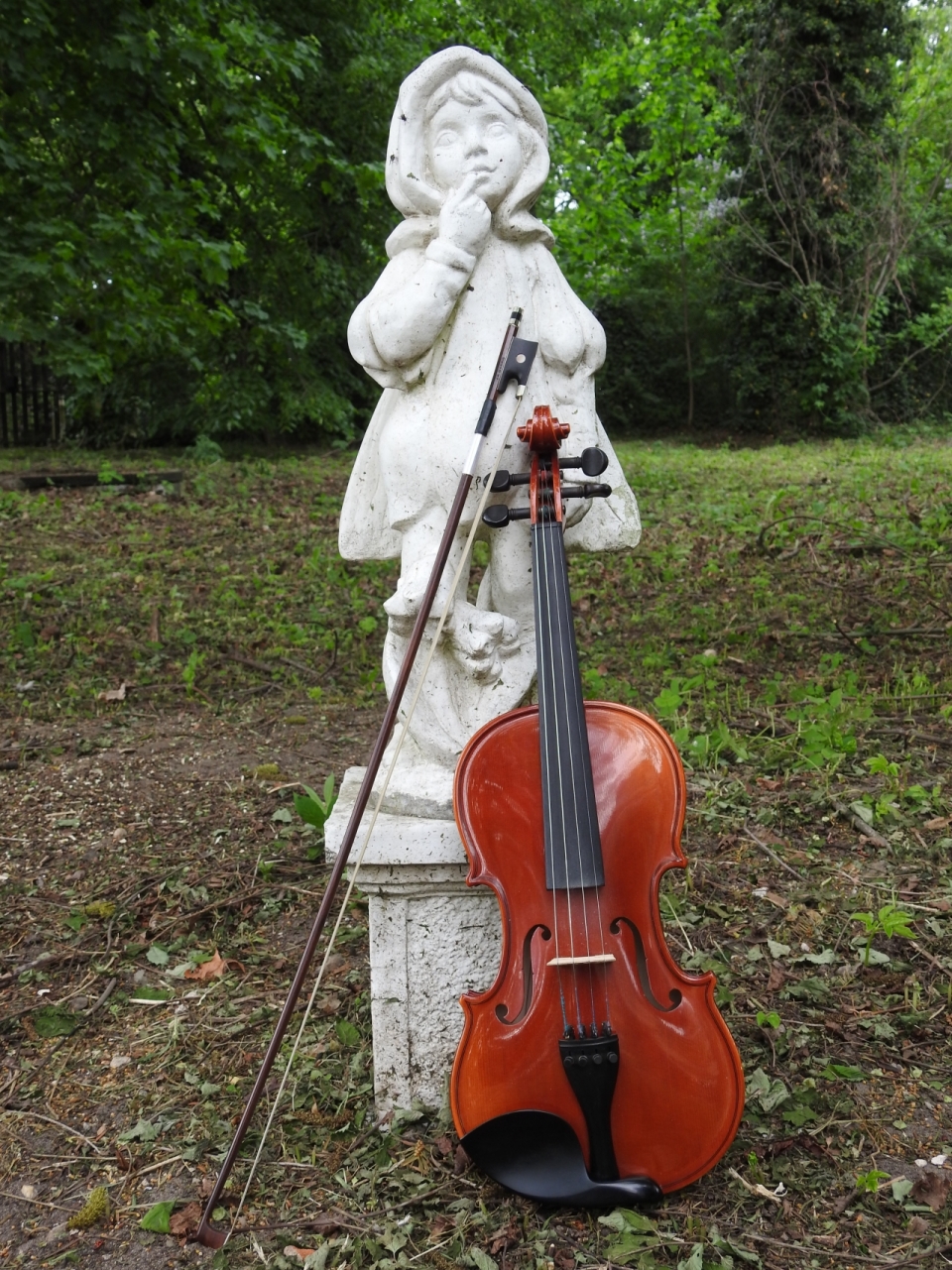自然公园白色儿童雕像前文艺古典小提琴乐器