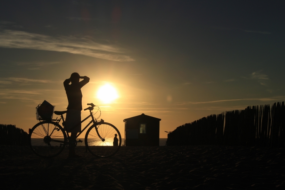 夕阳海滩边骑车男子剪影光影摄影