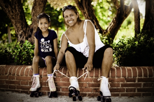 城市街道花坛边穿白色旱冰鞋母女