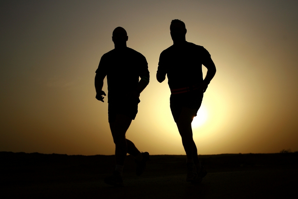 两个人在夕阳下跑步做运动逆光人像剪影
