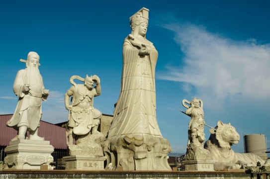 天空下高矮不一神话角色石雕