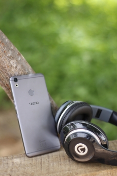 虚化背景树木树枝上银色手机耳机