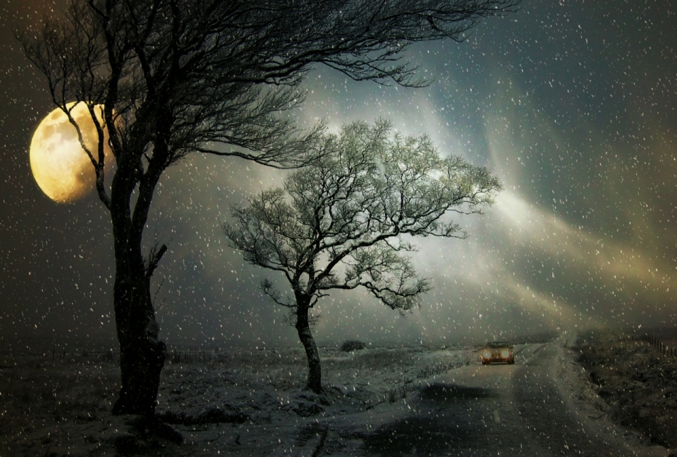星空下飘雪的乡间公路上出现的极光
