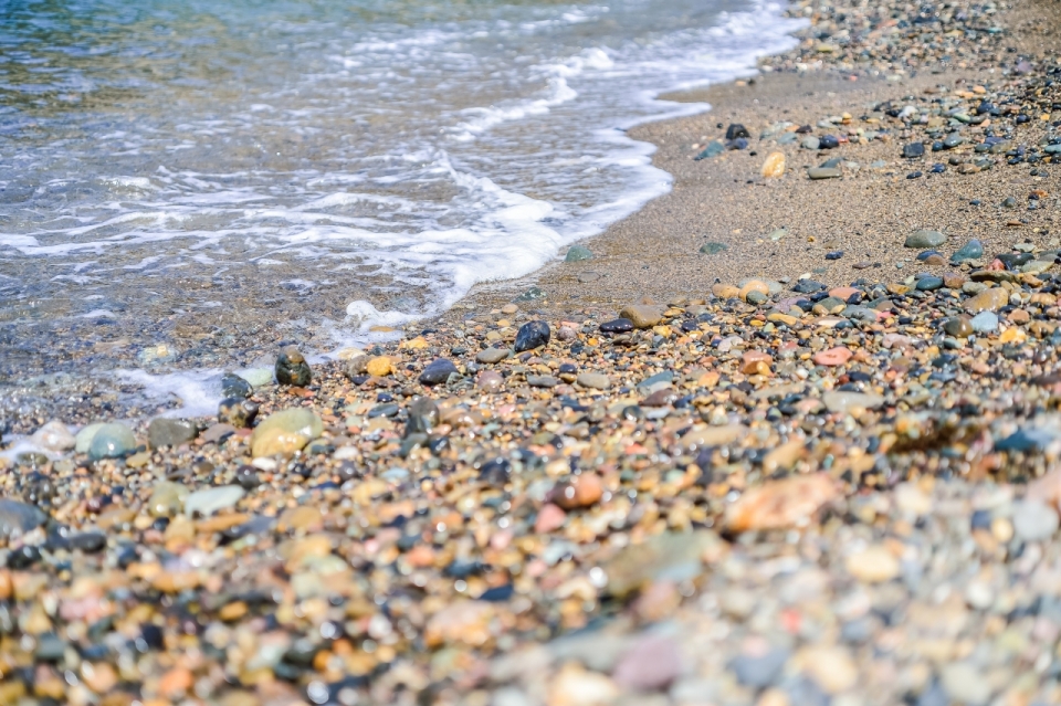 沙滩旁海水冲刷彩色鹅卵石自然风光