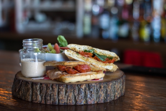 背景虚化原木盘子上的汉堡和奶茶