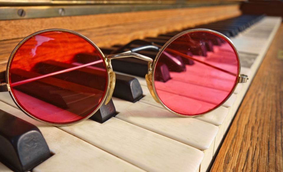 木制古典钢琴琴键上金框红色镜片眼镜