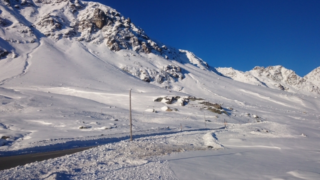 巍峨雪山山麓下险峻的公路
