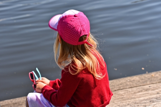 城市街道湖泊边拿太阳镜戴帽子金发女孩