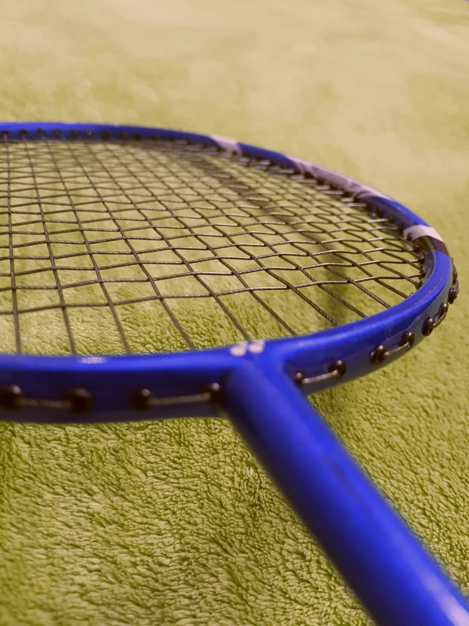 室内绿色毛毯上蓝色边框专业运动网球拍