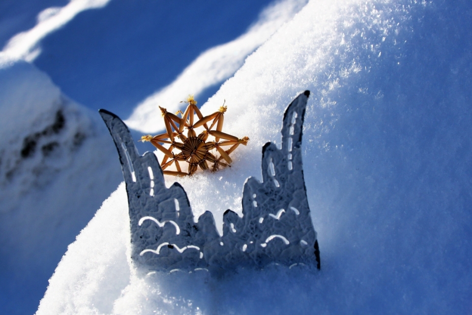 阳光下插在雪地上的雪花工艺品和翅膀纸片