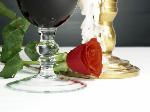 盛开红玫瑰鲜花和高脚杯玻璃杯