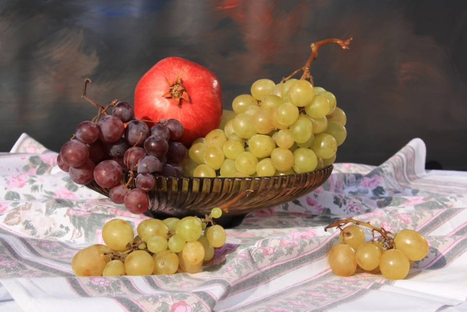 桌布上果盘中的葡萄和石榴水果水彩绘画