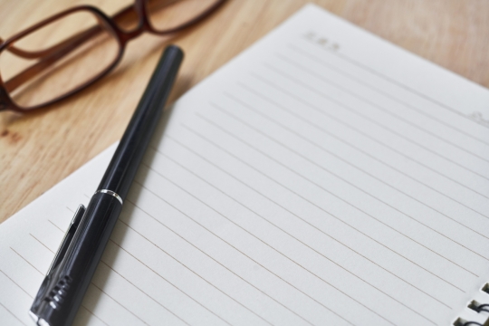 在木桌上的眼睛和笔记本静物摄影