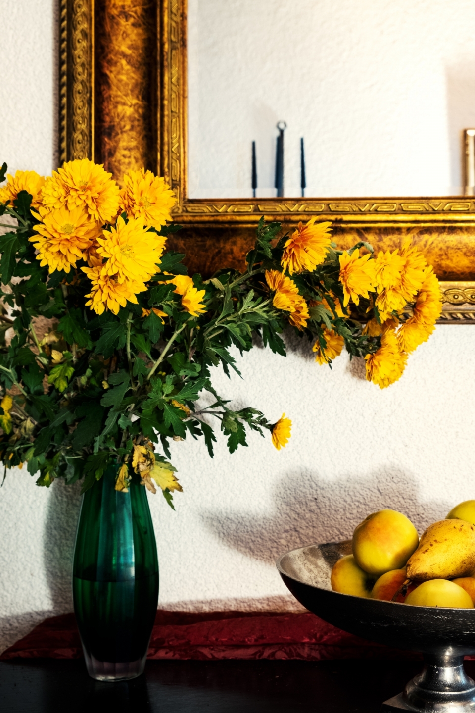 木桌上插满菊花的花瓶和水果盘静物摄影