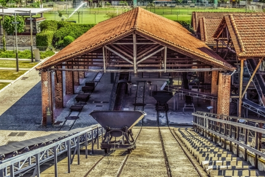 阳光下煤矿场的矿车运输铁轨和房屋