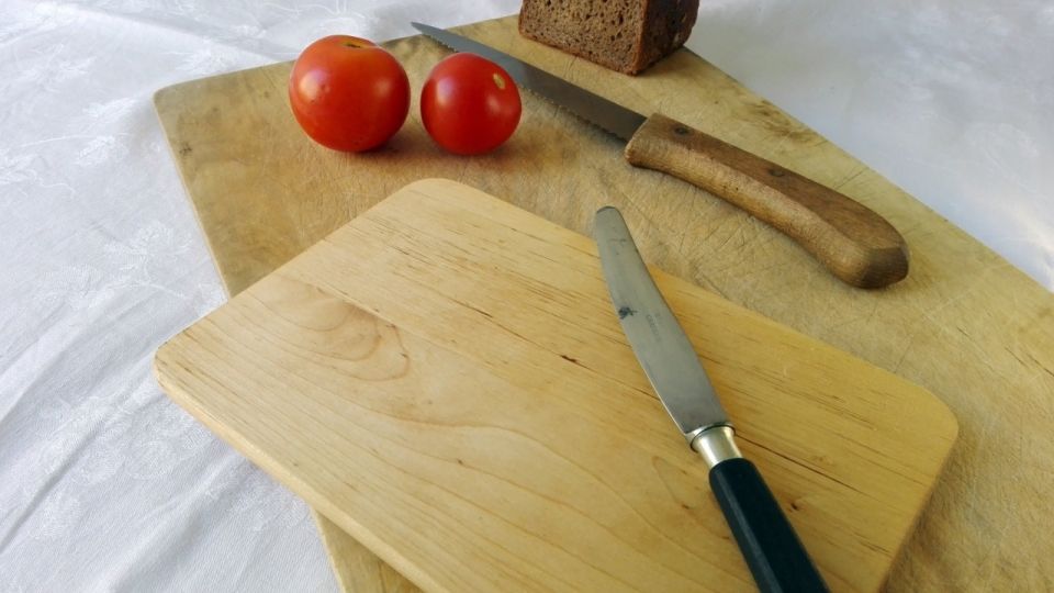 白色桌布案板上西红柿与菜刀摄影