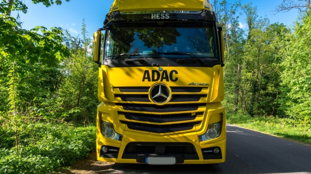 草地公路旁停靠黄色奔驰货车外观