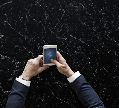 黑色大理石桌面前使用手机商务男性