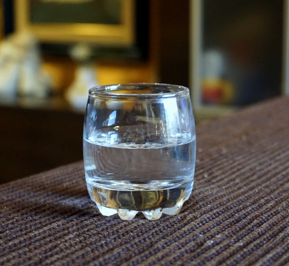背景虚化毛线桌布上装水玻璃杯摄影