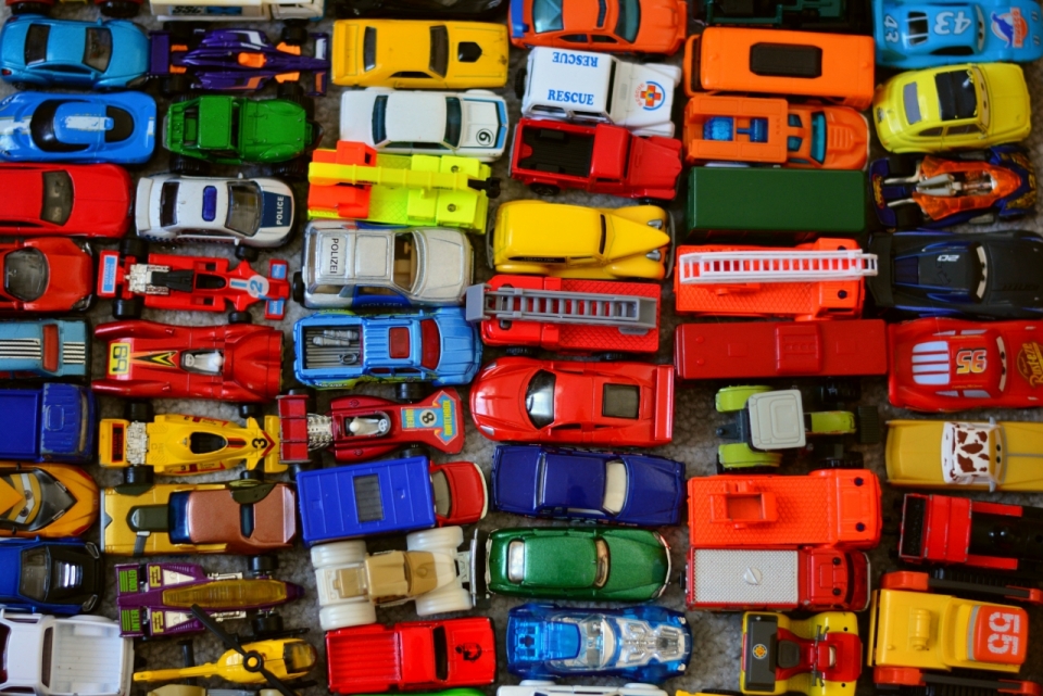 仓库地面堆积各色玩具汽车模型静物