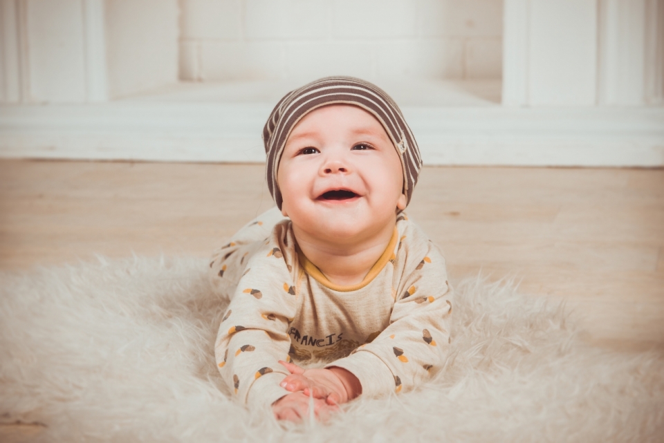 地毯上开心玩耍婴儿笑容特写