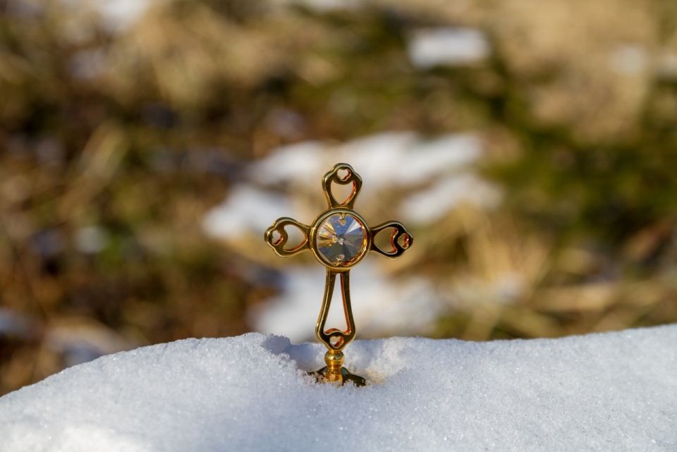 冬天雪后地面白雪中金色金属十字架装饰
