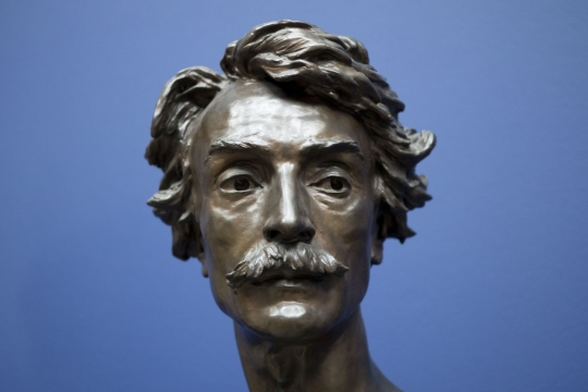 蓝色背景蓄胡短发男性金属头部塑像