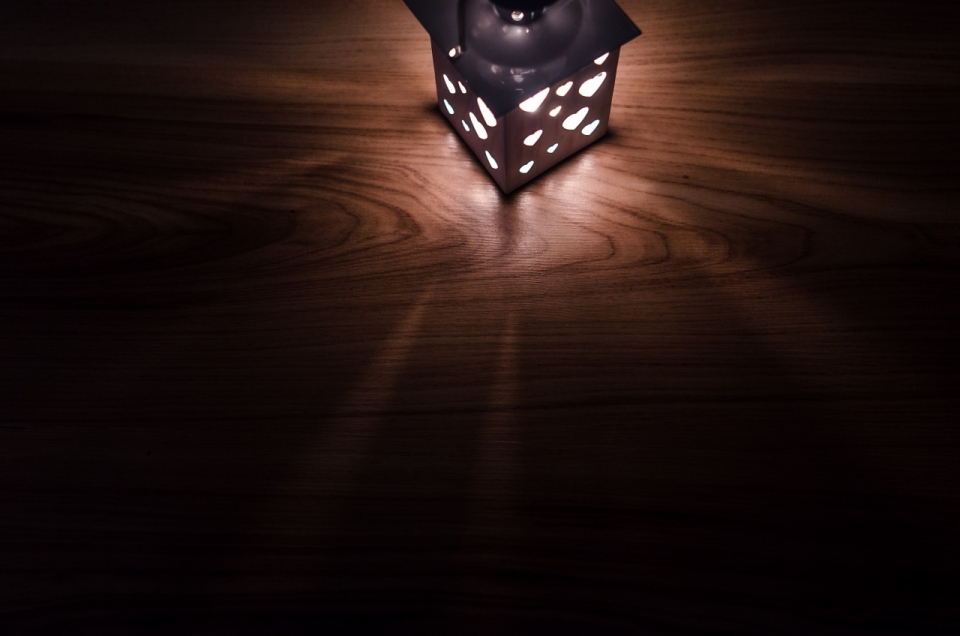 黑暗处木质桌面上艺术油灯静物摄影