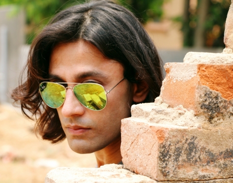 城市街道破旧建筑墙壁前短发墨镜男性