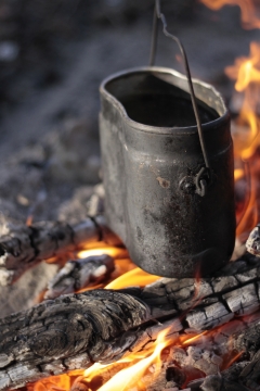 背景虚化木头炭火上煮的水壶