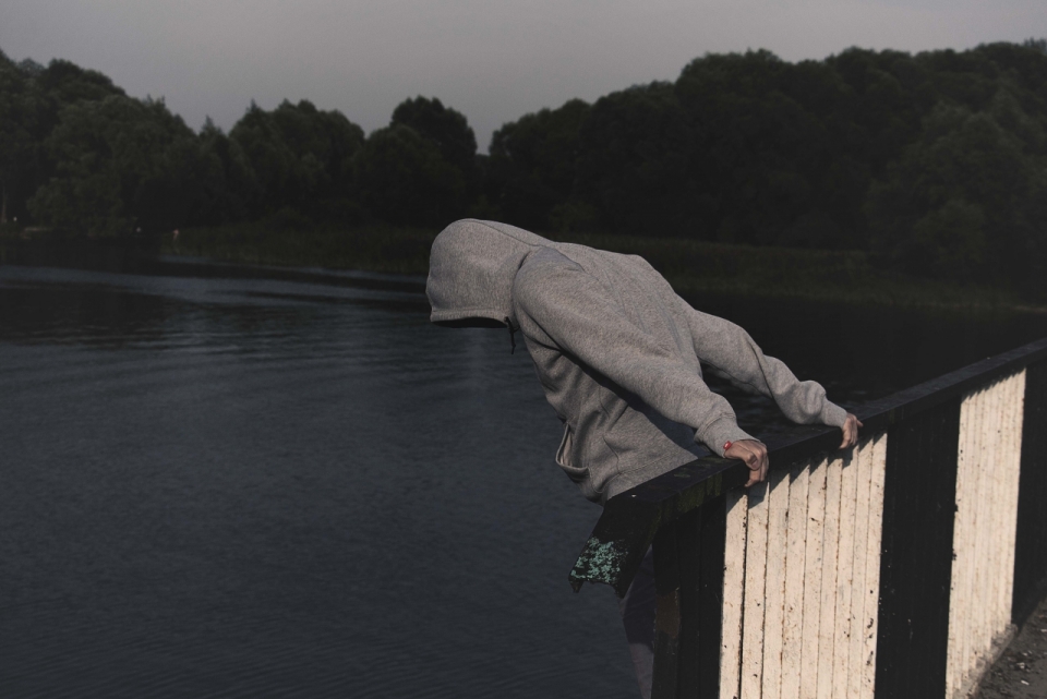 夜色男子反手拉在湖面桥围栏外创意摄影