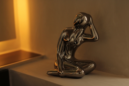 夜晚灯光室内墙壁前黑色金属艺术塑像