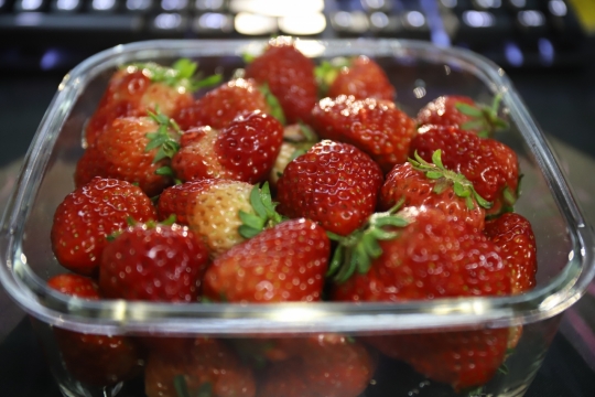 虚化背景室内键盘前玻璃容器新鲜草莓