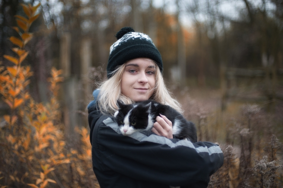 背景虚化树林前抱着黑猫的金发少女写真