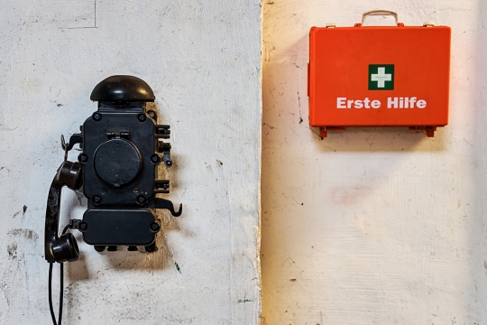 墙壁上悬挂的老式电话和医疗箱特写