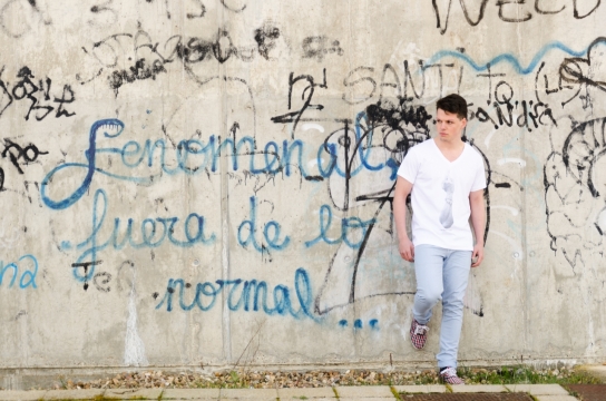 倚靠着涂鸦墙的白衣男孩