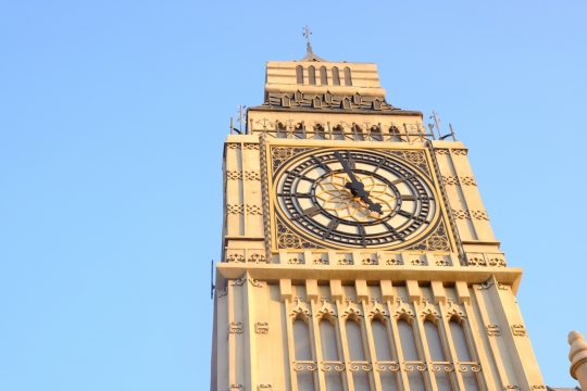 蓝色天空高大钟楼建筑外墙雕刻