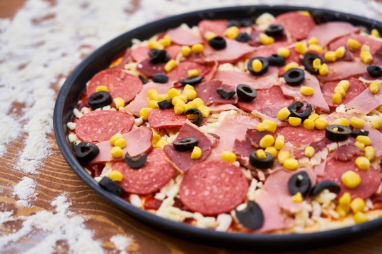 尚未烘烤的香肠芝士火腿玉米披萨美食摄影