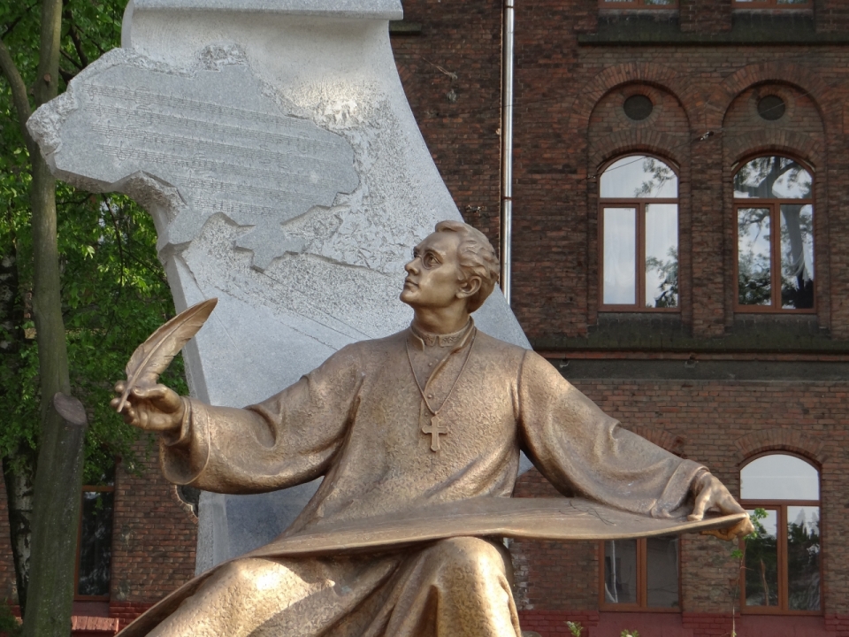 广场中拿着羽毛笔书写的神父雕像
