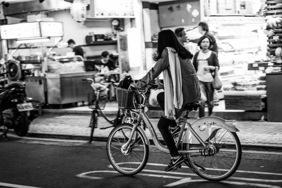 马路上骑公共自行车的女人黑白风格摄影