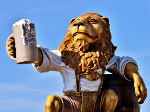 阳光蓝色天空举啤酒杯彩色狮子拟人塑像