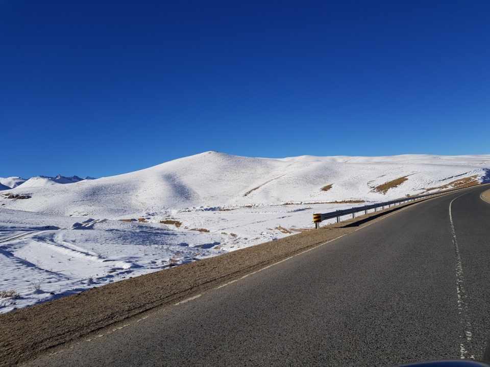 高原雪山旁沥青公路风光