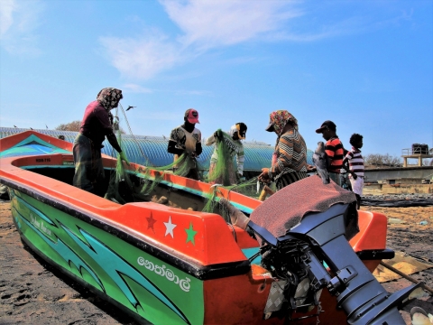 海边渔民清晨船只渔网准备人群